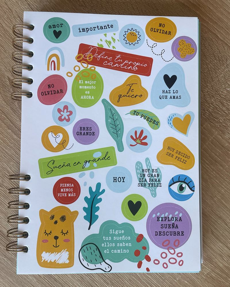 Hoja de stickers a todo color, con frases y dibujos para marcar las páginas, sobre la tapa del cuaderno.